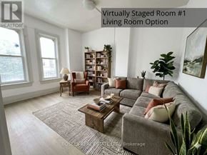 Toronto (Kensington-Chinatown) apartment for rent - A living room with a grey couch, a wooden coffee table, a bookshelf, and a potted plant.