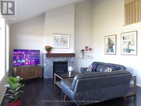 Collingwood townhouse for rent - A living room with a black couch and a fireplace.