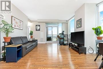 Mississauga (City Centre) condo for rent - A living room with a black leather couch and a television.