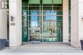 Mississauga (City Centre) condo for rent - The entrance to a building with glass doors and a number 208 on the wall.