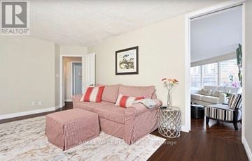Toronto (Mimico) condo for rent - A living room with a pink couch and a painting on the wall.