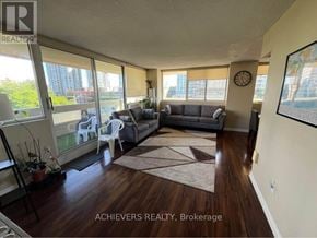 Mississauga (Mississauga Valleys) condo for rent - A living room with a couch, chairs, and a rug in front of a large window.