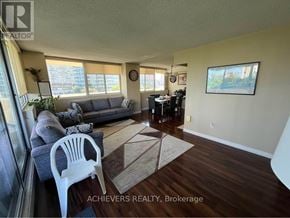 Mississauga (Mississauga Valleys) condo for rent - A living room with a couch, chair, and a rug.