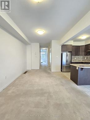 Brant (Paris) townhouse for rent - A spacious, empty room with a kitchen area in the background.