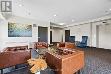St. Catharines (Lakeport) condo for rent - A living room with brown leather furniture and a painting on the wall.