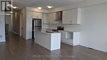 Brampton (Bram West) townhouse for rent - A kitchen with white cabinets and a wooden floor.