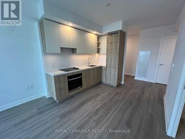 Vaughan (Concord) condo for rent - A kitchen with a wooden floor and white walls.