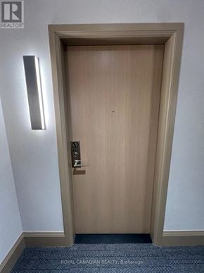 Vaughan (Concord) condo for rent - A wooden door with a handle and a light on the wall.