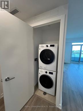 Vaughan (Concord) condo for rent - A white door with a washing machine and dryer stacked on top of each other.