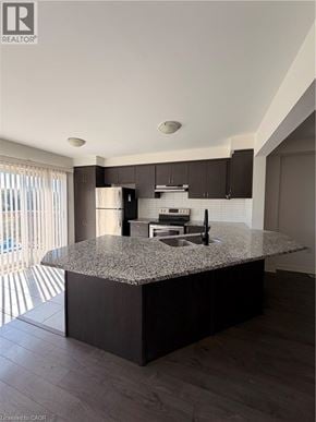 Cambridge townhouse for rent - A modern kitchen with granite countertops and dark wood cabinets.