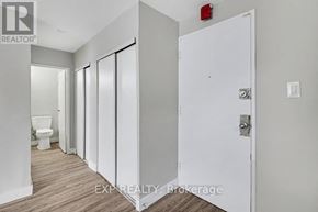 Ottawa condo for rent - A white door with a silver handle is in a room with a toilet in the background.