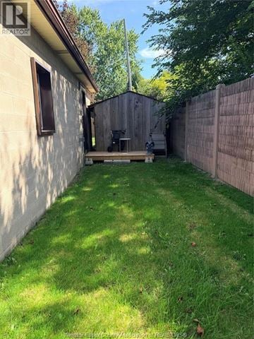 Windsor apartment for rent - A backyard with a wooden fence and a small patio area.