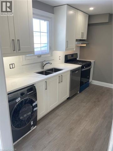 Hamilton apartment for rent - A realtor photo of a kitchen with a washer and dryer built in.