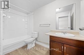 Ottawa condo for rent - A white bathroom with a toilet, sink, and bathtub.