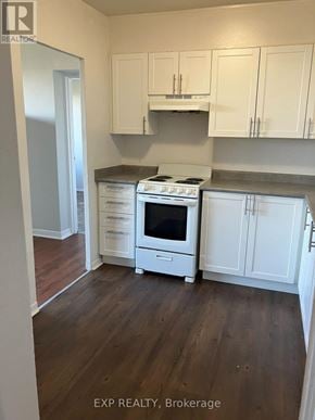 Ottawa condo for rent - A kitchen with white cabinets and a stove top oven.