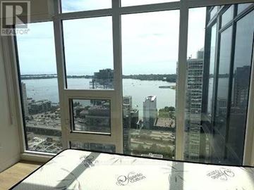Toronto (Waterfront Communities) condo for rent - A bedroom with a large bed and a view of the water.