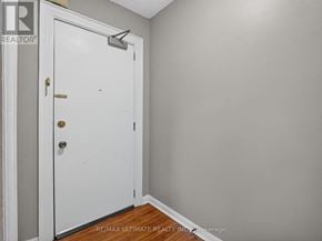 Toronto (The Beaches) multi-family for rent - A white door with a brass handle and a keyhole is in a room with a grey wall.