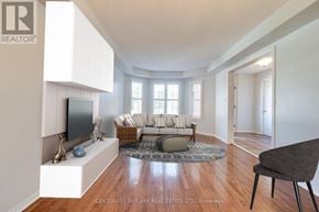 Mississauga (Lisgar) apartment for rent - A living room with a grey sofa and a wooden floor.
