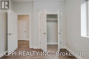 Port Colborne (Main Street) townhouse for rent - A real estate image of a room with white walls and a wooden floor.