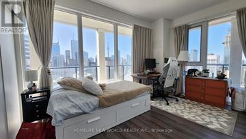 Toronto (Bay Street Corridor) condo for rent - A bedroom with a large bed and a desk with a chair.