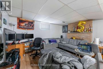 Mississauga (Malton) apartment for rent - A living room with a grey couch and a fireplace with a number 5 on it.