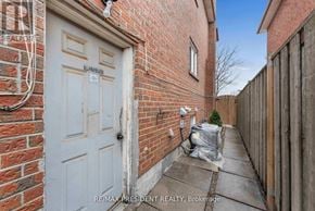 Mississauga (Malton) apartment for rent - A white door is on the left side of a brick wall.