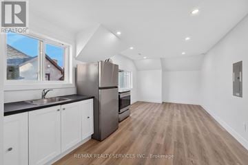Welland (Welland Downtown) condo for rent - A kitchen with white cabinets and a black countertop.