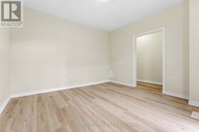 Ottawa triplex for rent - A room with wooden flooring and white walls.