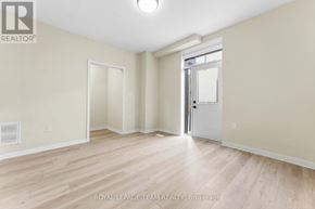 Ottawa triplex for rent - A spacious room with wooden flooring and white walls.