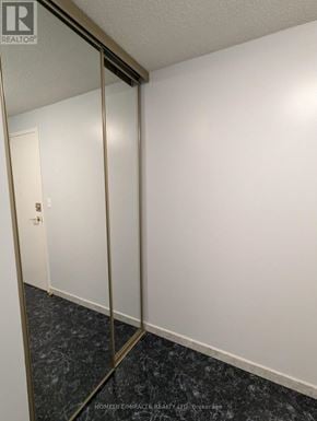Mississauga (Cooksville) condo for rent - A hallway with a marble floor and a mirrored door.