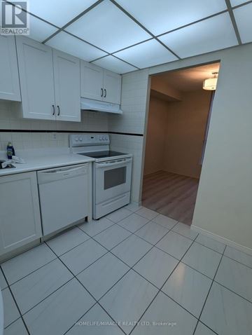 Mississauga (Cooksville) condo for rent - A kitchen with white cabinets and a white tiled floor.