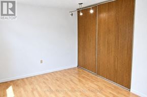 London South (South J) condo for rent - A room with a wooden floor and a white wall with a sliding door.