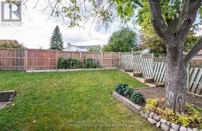 Cambridge apartment for rent - A backyard with a fence, a tree, and a small garden.