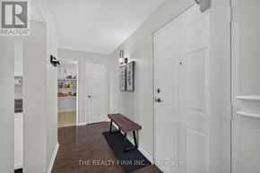 London East (East K) condo for rent - A hallway with a bench and a door on the right.