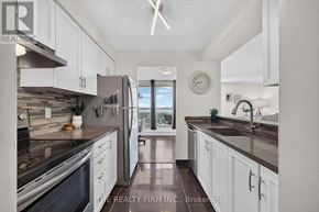 London East (East K) condo for rent - A kitchen with white cabinets and a stainless steel refrigerator.
