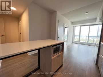 Toronto (Regent Park) condo for rent - A modern kitchen with wooden cabinets and a large island.