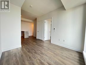 Toronto (Regent Park) condo for rent - A spacious room with wood flooring and white walls.