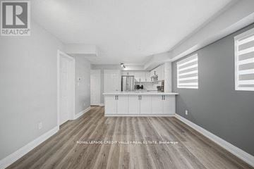 Toronto (Niagara) townhouse for rent - A spacious kitchen with white cabinets and a wooden floor.