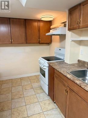 Toronto (Rouge) apartment for rent - A kitchen with brown cabinets and a white dishwasher.