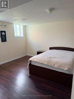 Toronto (Rouge) apartment for rent - A bedroom with a bed, wooden floors, and a window.