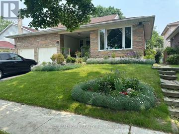 Toronto (L'amoreaux) apartment for rent - A house with a front yard and a black car parked in the driveway.