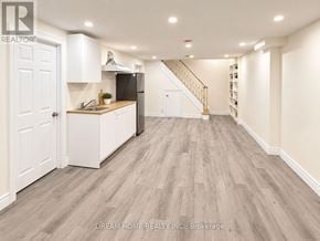 Toronto (L'amoreaux) apartment for rent - A well-lit, spacious kitchen with white cabinetry and a wooden floor.