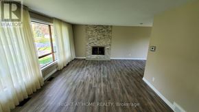Toronto (Willowdale West) apartment for rent - A room with a stone fireplace and wood flooring.