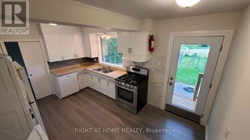 Toronto (Willowdale West) apartment for rent - A kitchen with white cabinets and a black stove top oven.