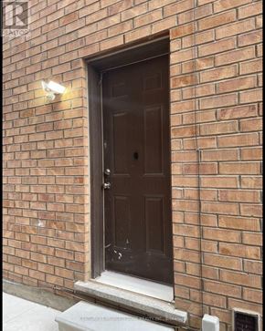 Brampton (Credit Valley) apartment for rent - A brown door is on a brick wall.