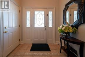 Niagara Falls (Ascot) apartment for rent - A hallway with a black mat on the floor and a vase of flowers on a table.