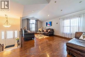Niagara Falls (Ascot) apartment for rent - A living room with a brown leather couch and a television mounted on the wall.