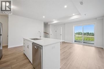 Kitchener townhouse for rent - A modern kitchen with white cabinets and a large window.