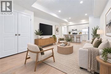 Kitchener townhouse for rent - A modern living room with a wooden chair and a grey sofa.