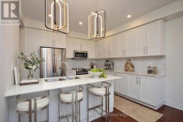 East Gwillimbury (Holland Landing) apartment for rent - A modern kitchen with white cabinets and a central island.
